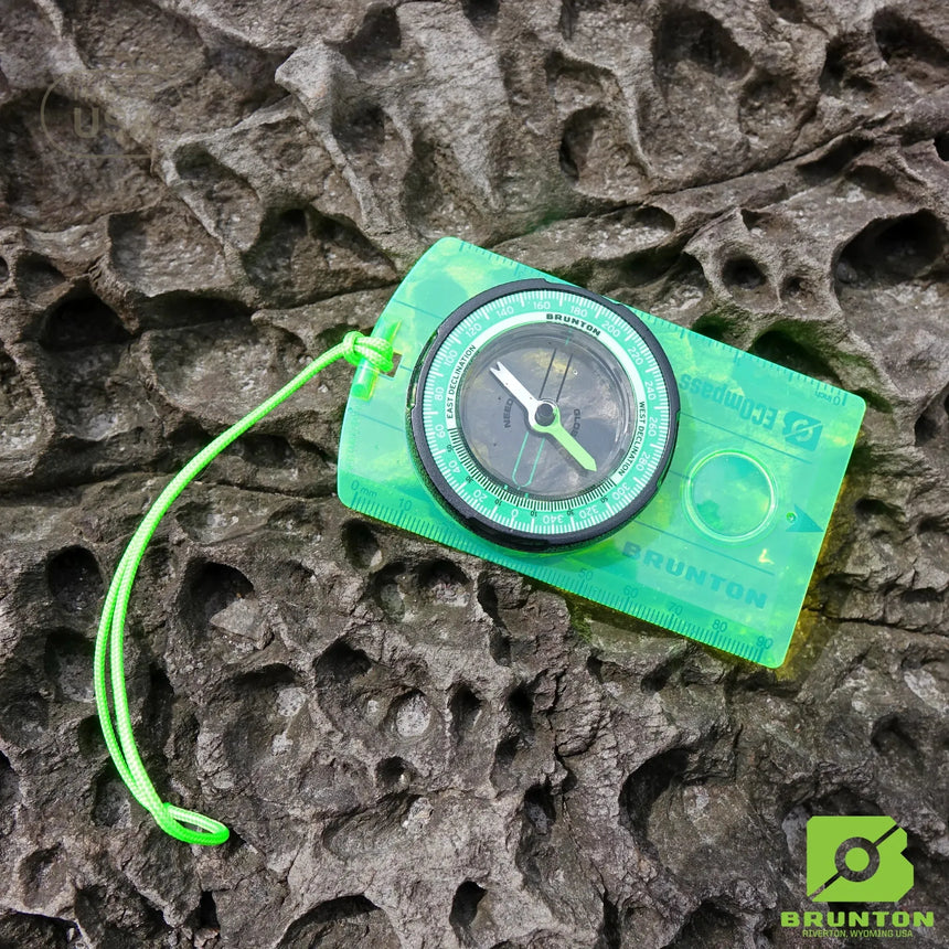 Compass on a textured stone surface with Brunton logo
