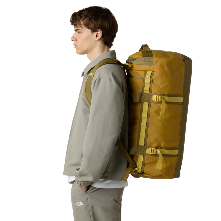 The North Face Base Camp Duffel Medium Golden Tan/Cedar - side view with detachable ergonomic shoulder straps and padded handles