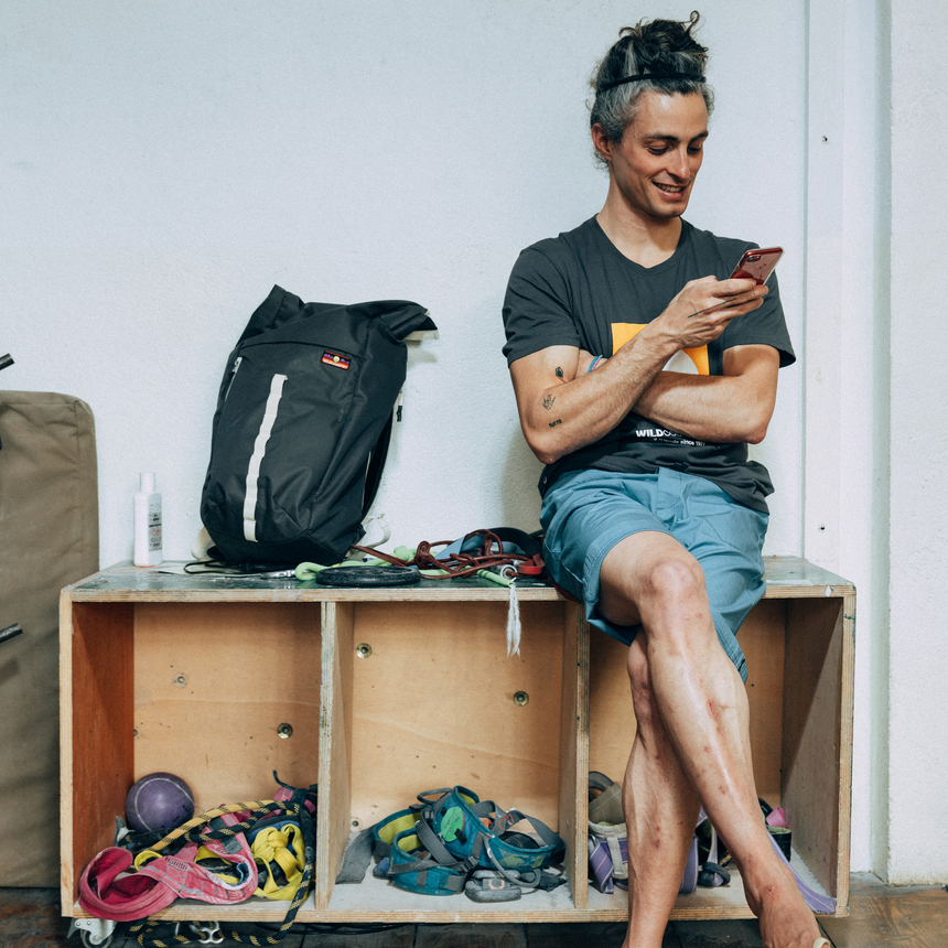 Wild Country Climbing Flow Back Pack - person sitting on box with pack next to them