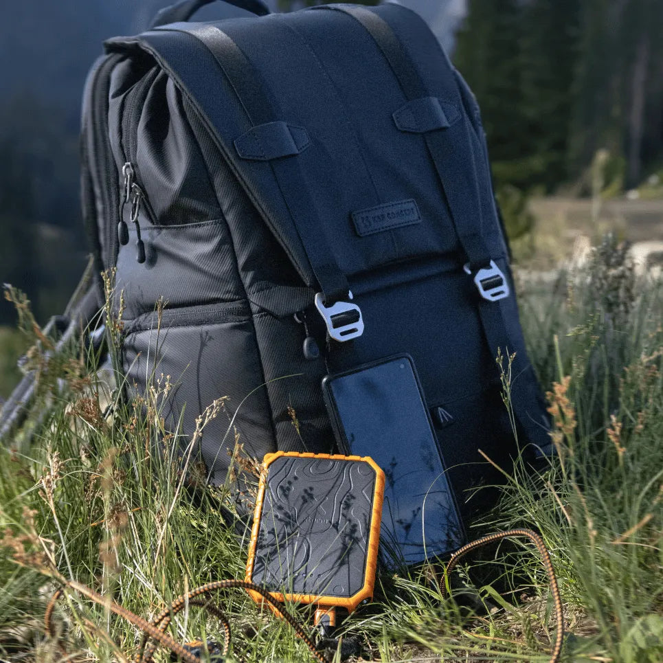 Backpack with a power bank in a grassy outdoor setting