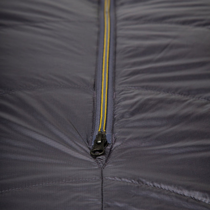 Mountain Equipment Helium GT 600 Sleeping Bag in Anvil Grey packed into waterproof roll-top stuff sack showing lightweight packable construction