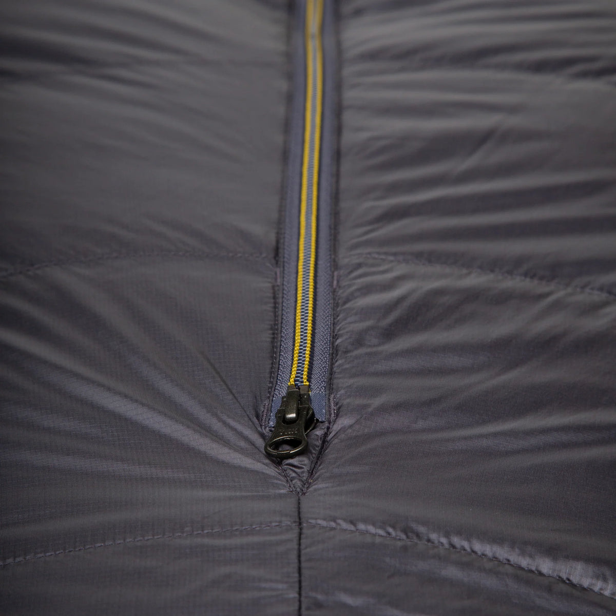 Mountain Equipment Helium GT 800 Sleeping Bag in Anvil Grey - lifestyle view showing warm roomy GT fit sleeping bag for cold-weather trekking and alpine use