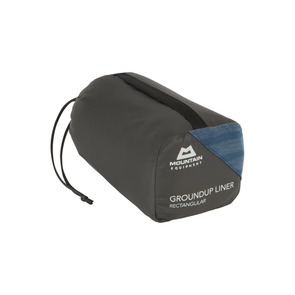 Mountain Equipment Groundup Rectangular Sleeping Bag Liner in Denim Blue in stuff sack showing lightweight packable construction