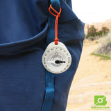Brunton compass on a blue backpack with a desert landscape in the background