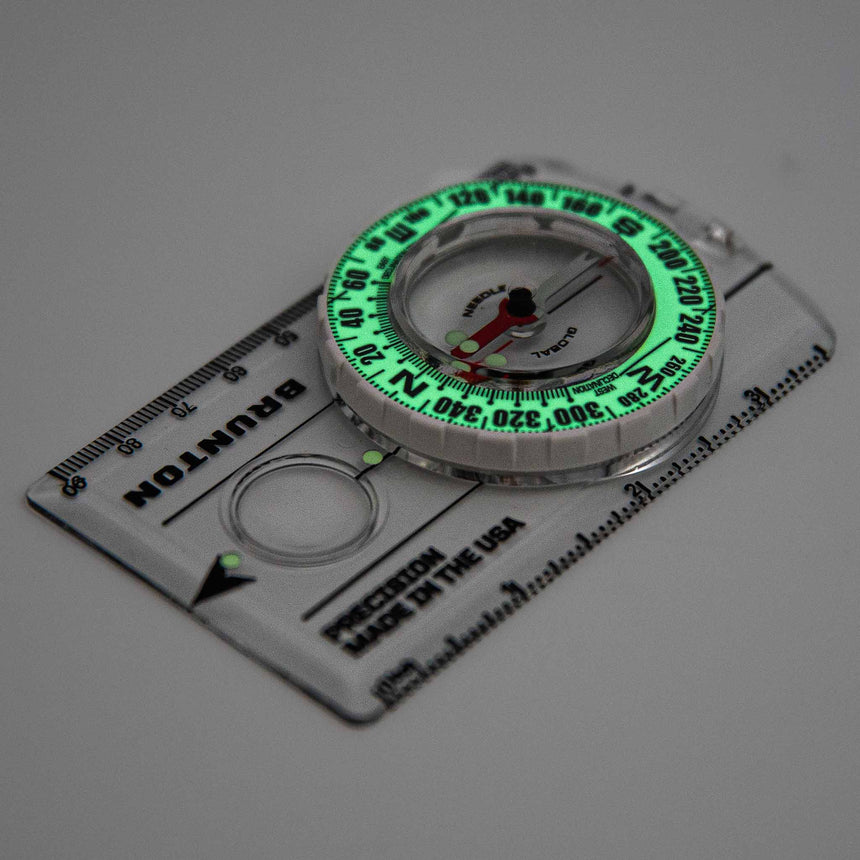 Compass with green glow on a white background