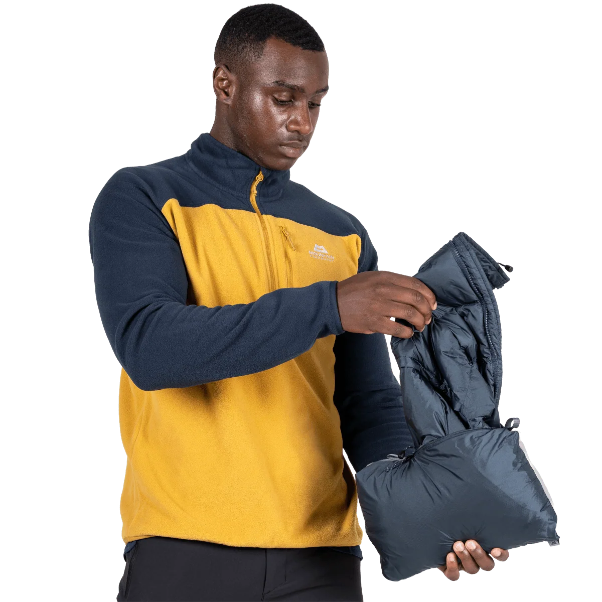 Mountain Equipment Lightline Men's Vest in Blue Nights packed into internal pocket on model showing lightweight packable construction