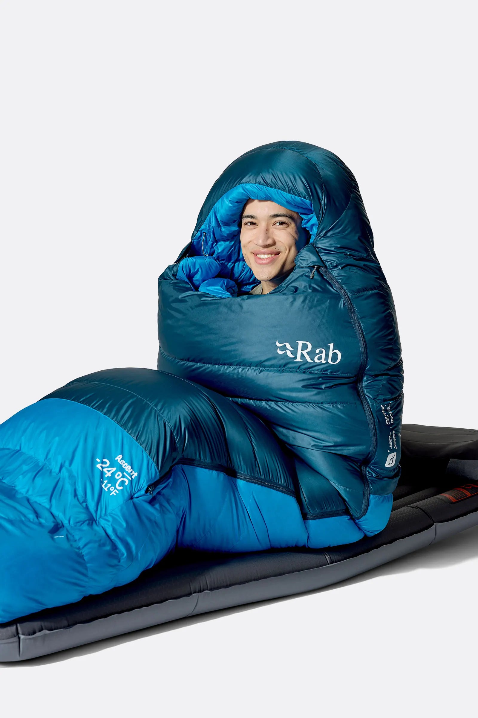 Rab Ascent Down Sleeping Bag (-18°C/0F) in Tempest Blue/Maya Blue - Model Seated Hood Close