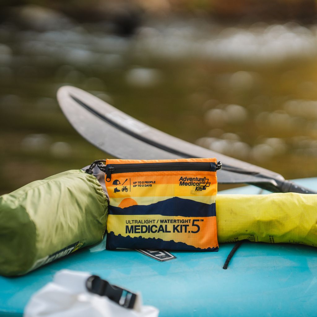 Adventure Medical Kits Ultralight Watertight .5 First Aid Kit beside a kayak