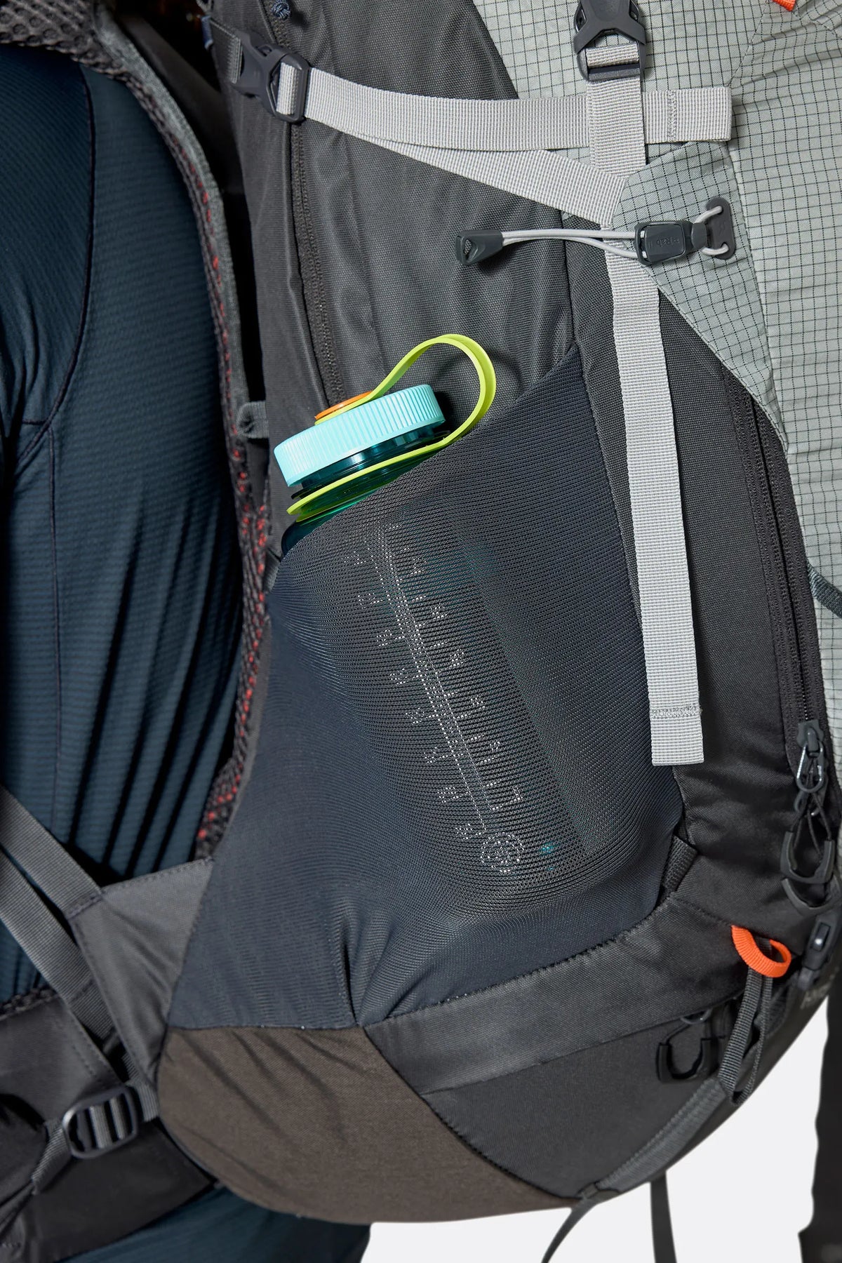Rab Hyperon 65L Trekking Pack in Dark Pewter/Anthracite - side stretch pocket with water bottle, worn