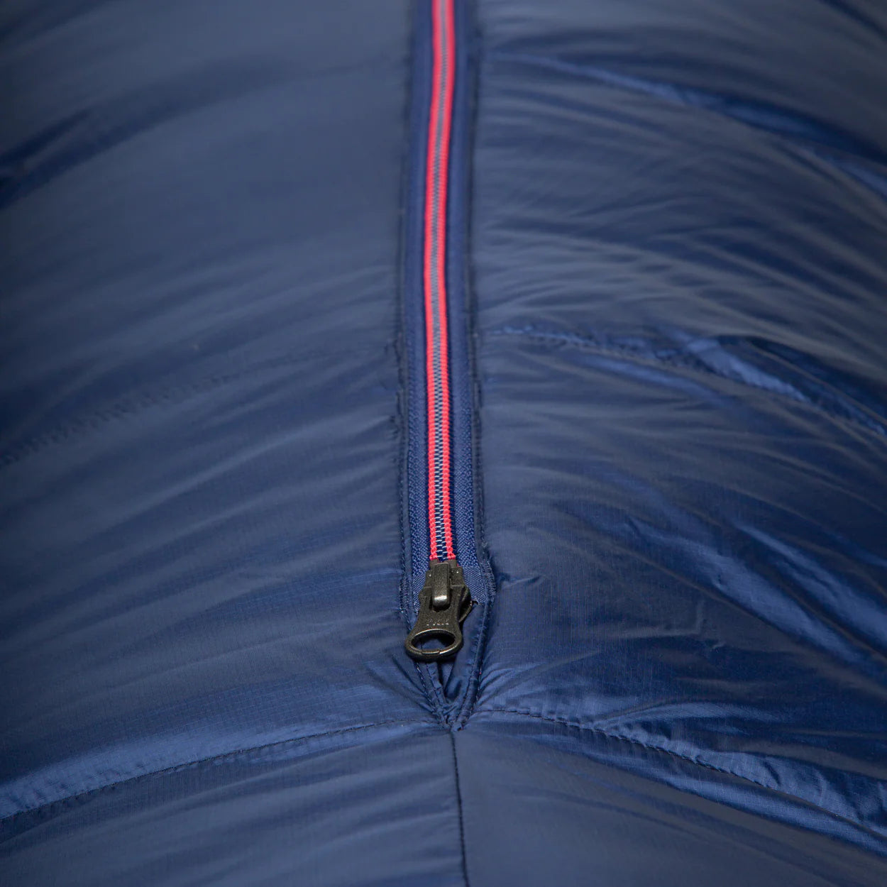 Mountain Equipment Helium 250 Women's Sleeping Bag in Medieval Blue packed into waterproof roll-top stuff sack showing compact 19 x 17 x 15 cm packed size