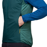 Mountain Equipment Switch Men's Vest in Pine/Fern packed into hand pocket showing lightweight packable construction with twin carabiner carry loops