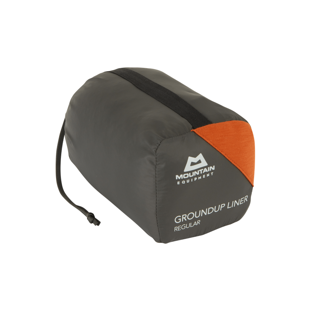 Mountain Equipment Groundup Mummy Sleeping Bag Liner in Paprika in stuff sack showing lightweight packable construction